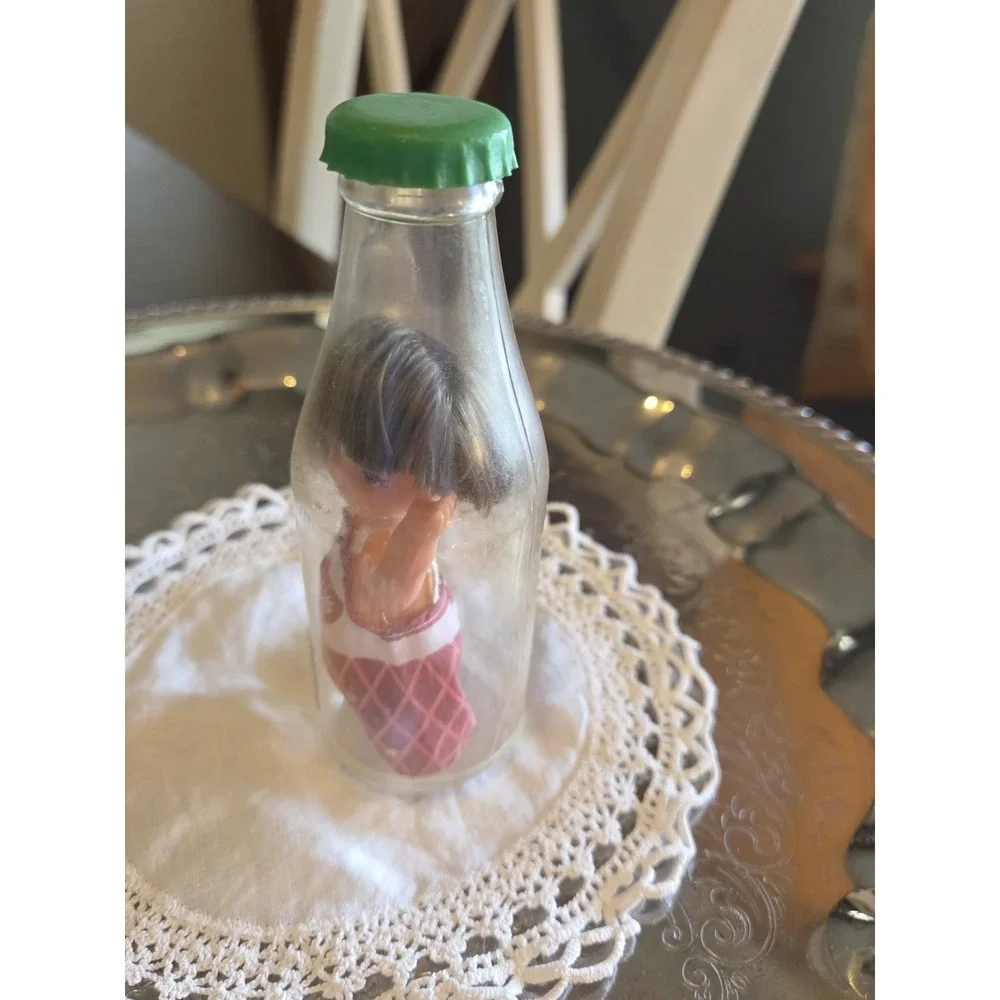 vintage 1960s Cola Kids doll is encased in a clear plastic bottle